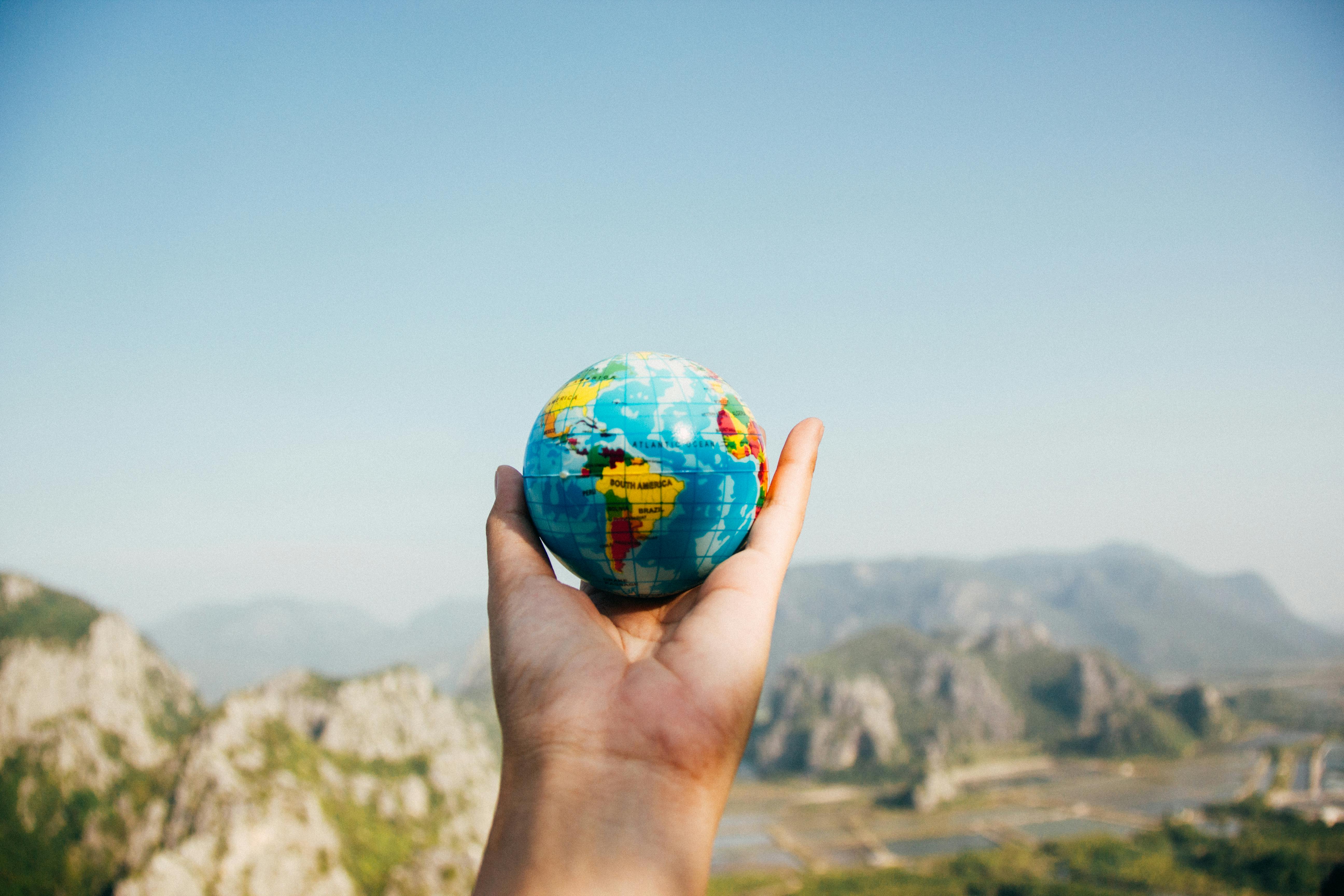 Globe in hand with mountains in the background